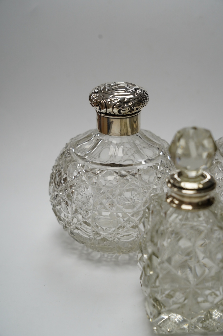 A pair of silver mounted cut glass scent bottles, marks rubbed, 12.3cm and one other silver mounted scent bottle. Condition - poor